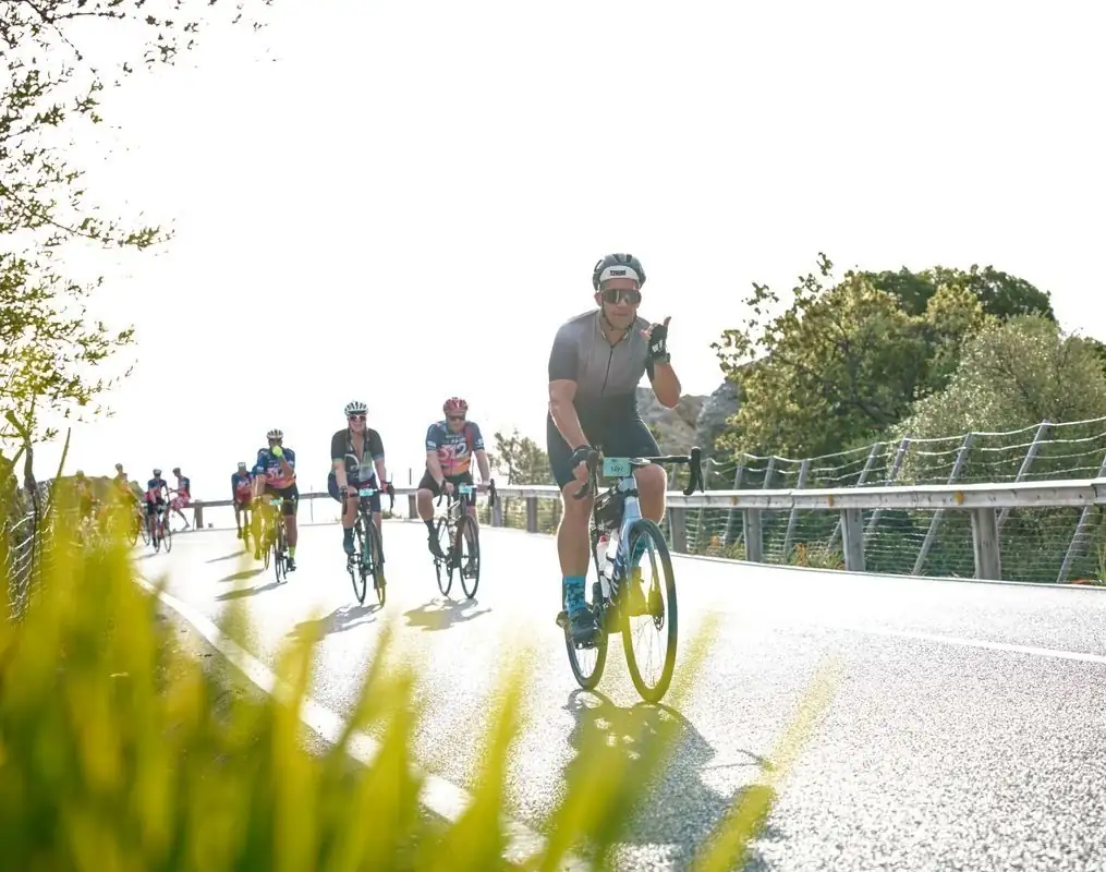 Gruppo di ciclisti durante una pedalata soleggiata su una strada costiera di Maiorca